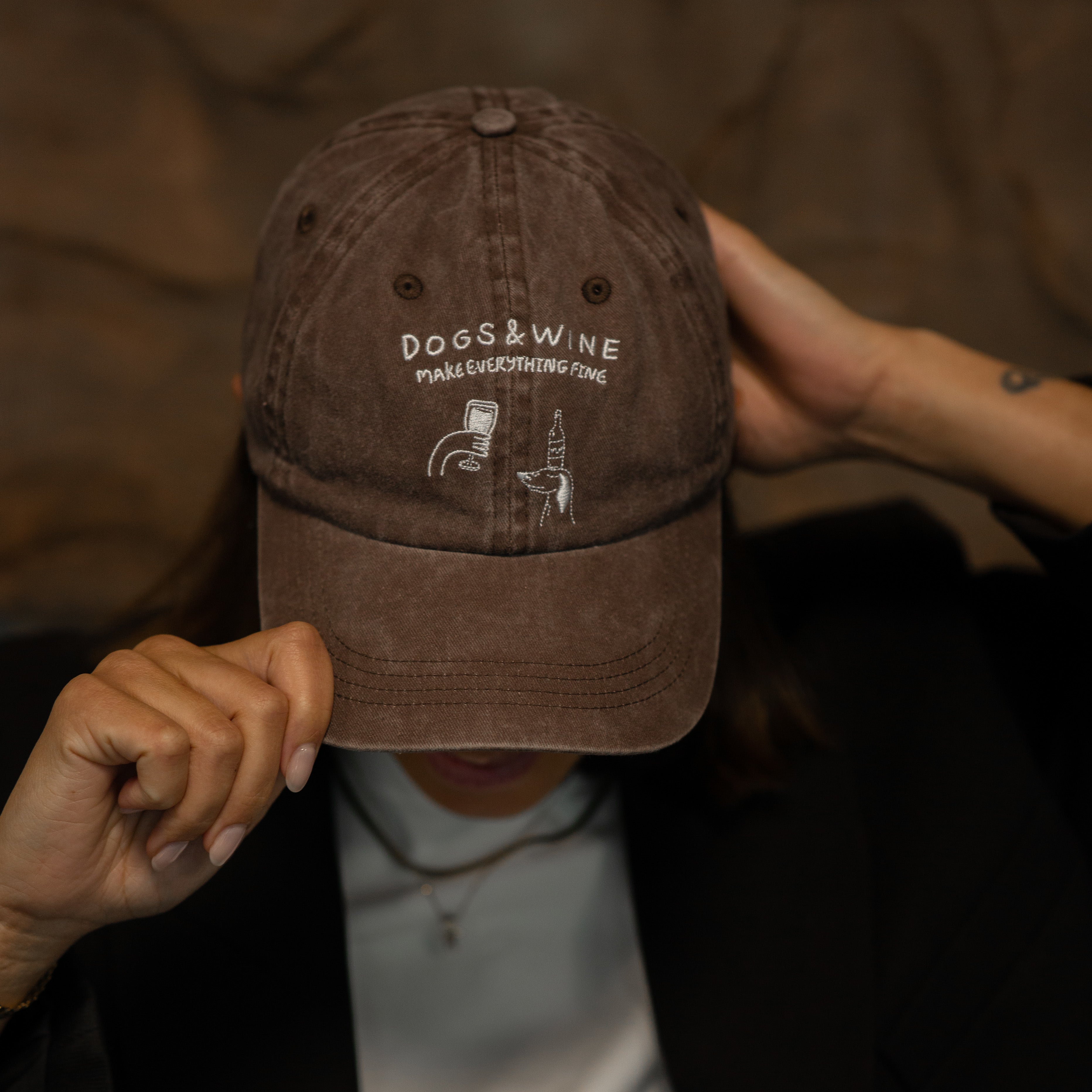 brown-denim-cap-dogs-and-wine-make-everything-fine-print-logo-wearing-woman.jpg